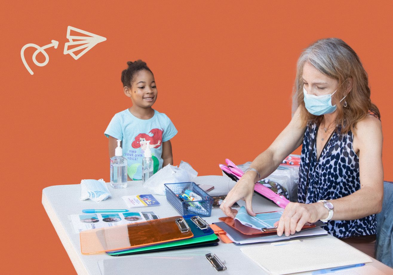 Child standing next to a woman while she addes a form to a clipboard