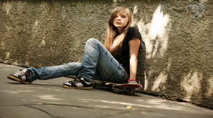 teen sitting against wall