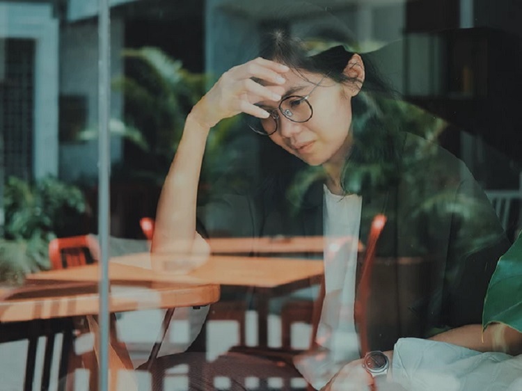 Woman thinking and looking at computer screen